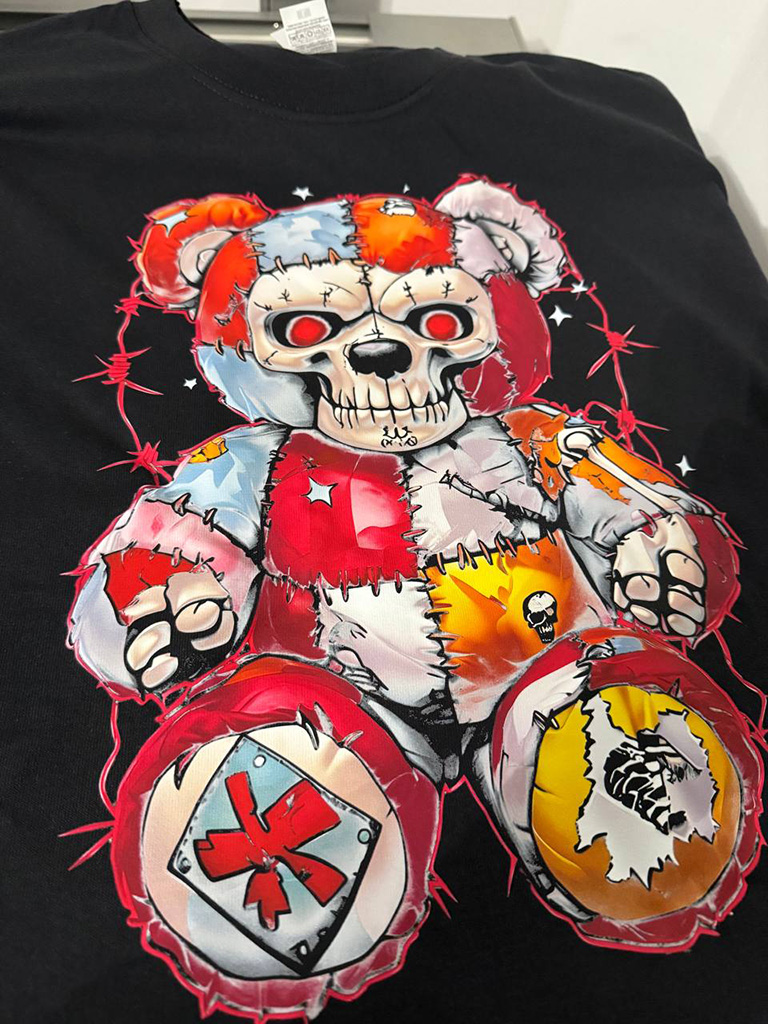 En närbild på en DTF-transfer som appliceras på en t-shirt med en värmepress.